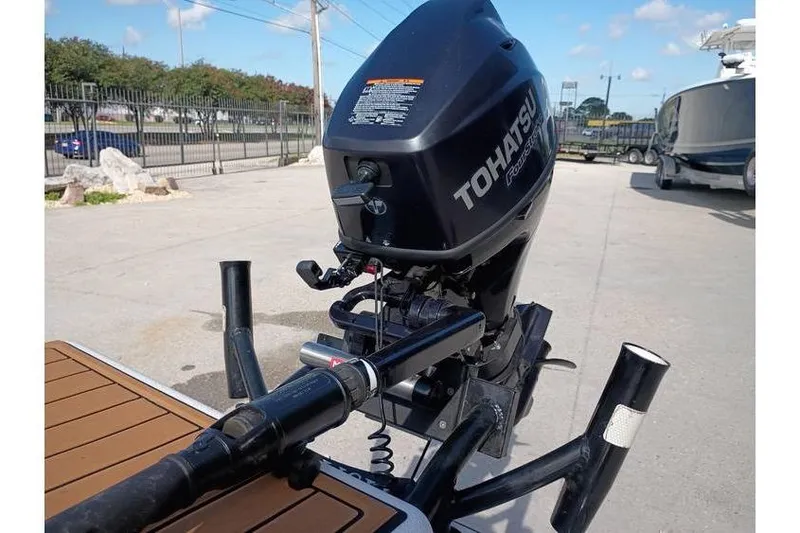 Slide: The Image of 2013 Pelican Ambush boat with Tohatsu motor on a trailer, equipped for fishing. - 5