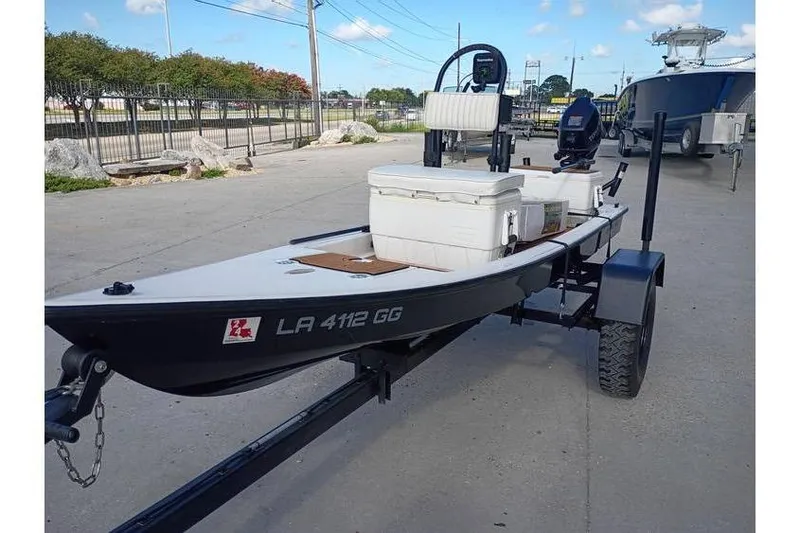Slide: The Image of 2013 Pelican Ambush boat with Tohatsu outboard motor, docked on concrete surface. - 8