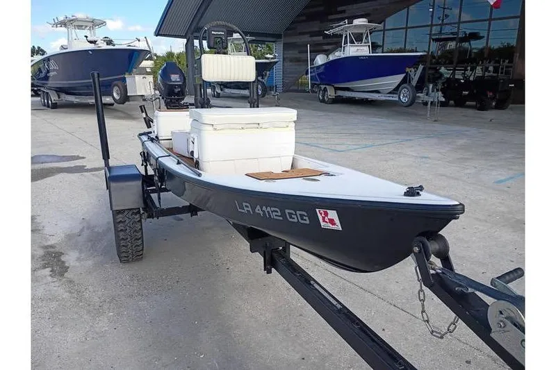 Slide: The Image of Tohatsu outboard motor on a 2013 Pelican Ambush boat, parked outdoors. - 9
