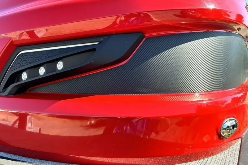 Slide: The Image of Close-up of 2022 Manitou XT 27 SRW's sleek red exterior and modern headlight design. - 10