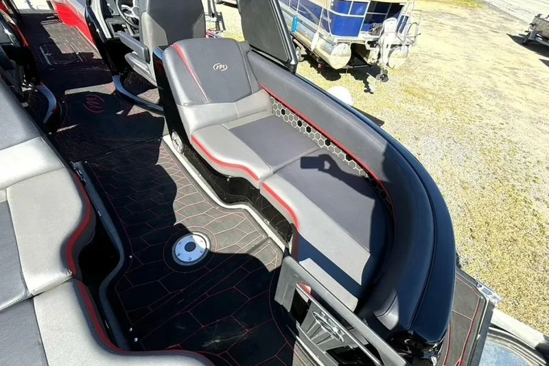 Slide: The Image of Luxurious seating on 2022 Manitou XT 27 SRW boat, featuring sleek black and red design. - 15