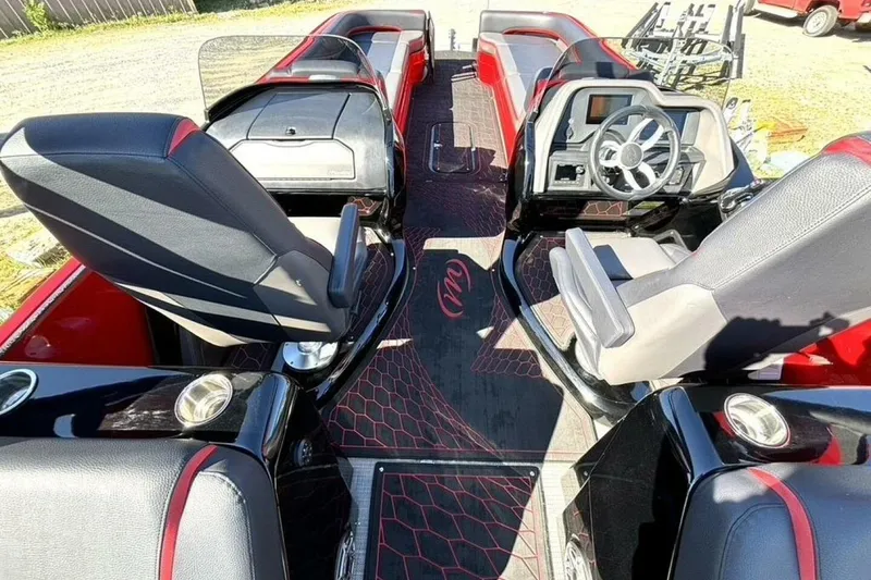 Slide: The Image of 2022 Manitou XT 27 SRW boat interior with sleek black and red seating and modern dashboard. - 16
