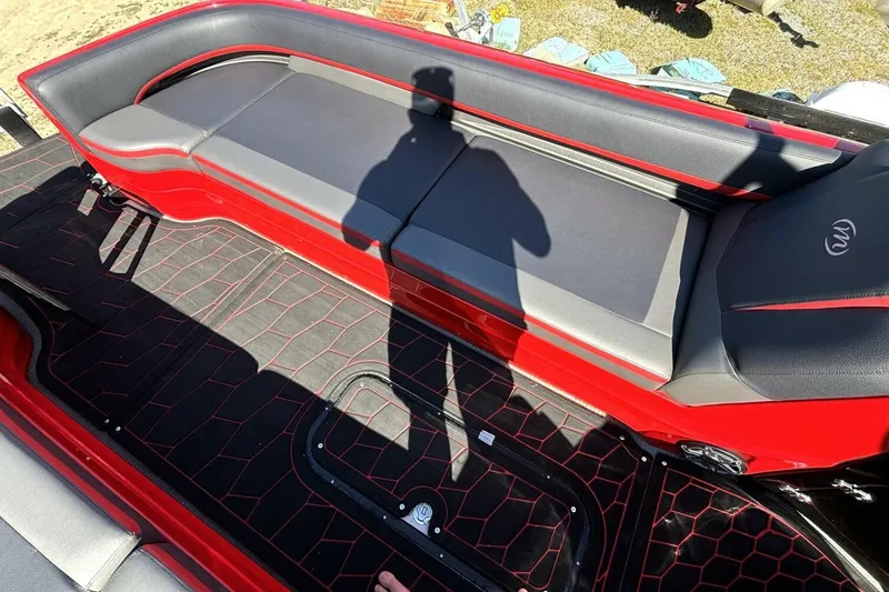 Slide: The Image of 2022 Manitou XT 27 SRW boat interior with red and black seating and flooring. - 26