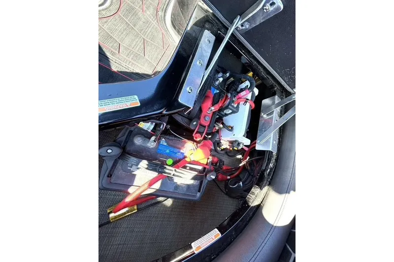 Slide: The Image of Battery compartment of 2022 Manitou XT 27 SRW with wiring and components visible. - 33