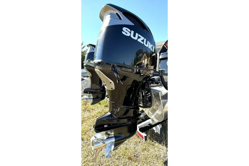 Slide: The Image of 2022 Manitou XT 27 SRW with Suzuki outboard motor, shiny black finish, outdoor setting. - 38