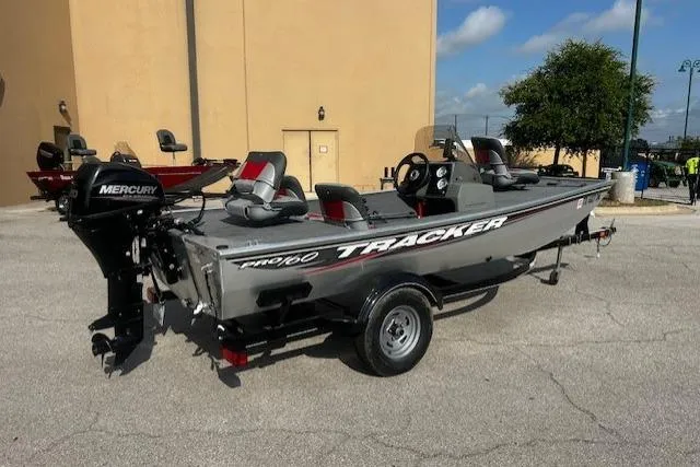 Slide: The Image of 2016 Tracker Pro 160 fishing boat with Mercury outboard motor, parked outdoors. - 3
