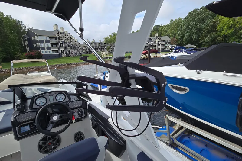 Slide: The Image of 2019 Axis T23 boat interior with steering wheel, docked near waterfront buildings. - 14