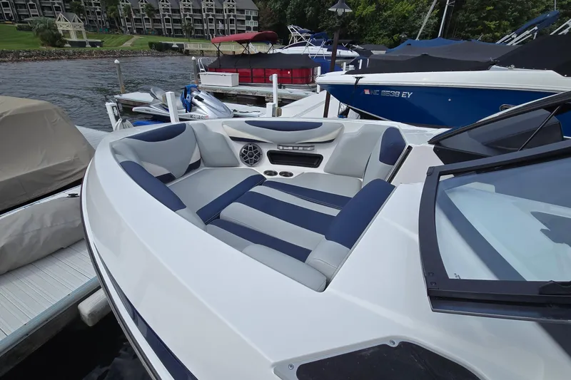 Slide: The Image of 2019 Axis T23 boat with blue and gray seating, docked by the waterfront. - 18
