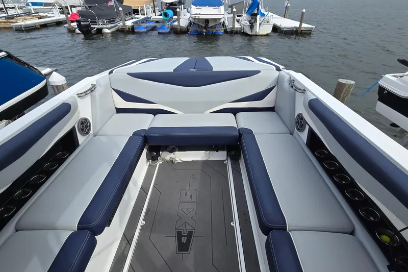 Slide: The Image of 2019 Axis T23 boat interior with blue and white seating at a marina. - 19