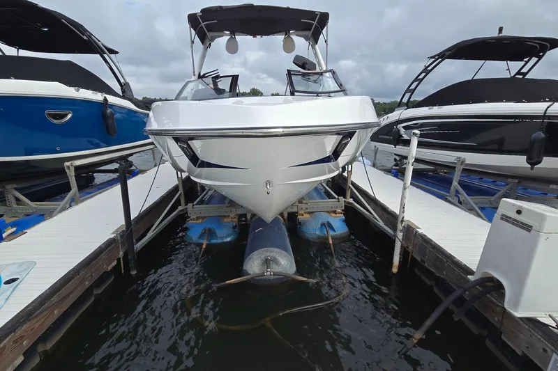 Slide: The Image of 2019 Axis T23 boat docked between two other boats on a cloudy day. - 2