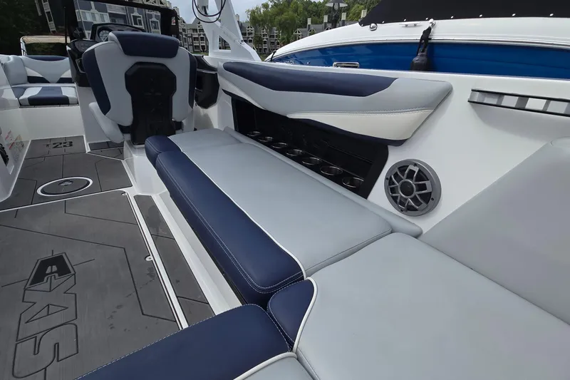 Slide: The Image of 2019 Axis T23 boat interior with blue and gray seating, speaker, and cup holders. - 22