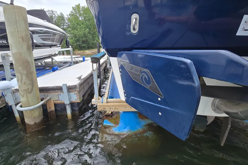 Slide: The Image of 2019 Axis T23 boat docked beside a wooden pier on a lake. - 24