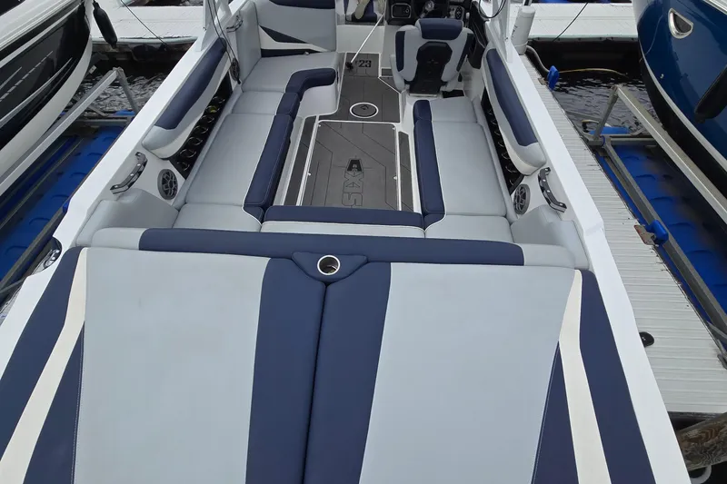 Slide: The Image of 2019 Axis T23 boat interior with blue and white seating at a dock. - 25