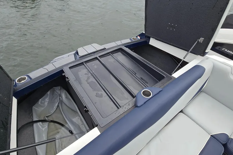Slide: The Image of 2019 Axis T23 boat storage compartment with open hatch, featuring cup holders and seating. - 26