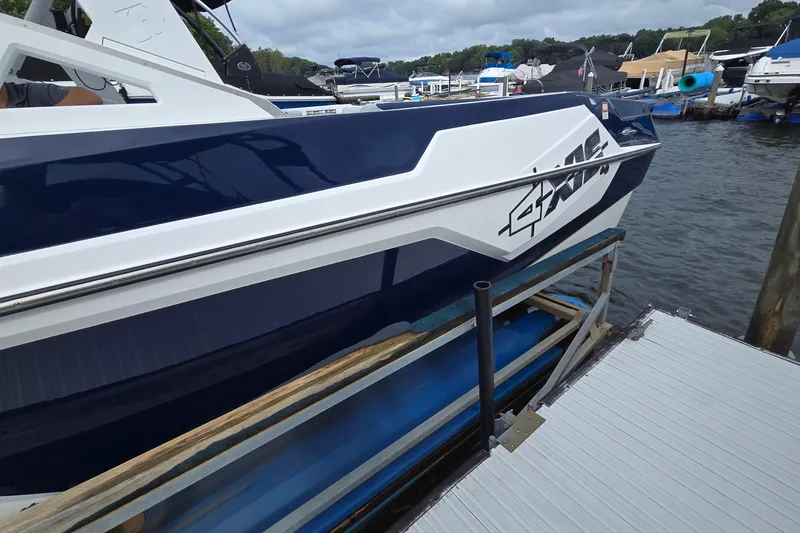 Slide: The Image of 2019 Axis T23 boat docked at a marina, featuring sleek blue and white design. - 4