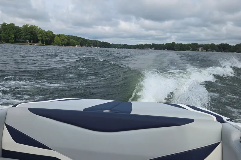 Slide: The Image of 2019 Axis T23 boat creating waves on a lake under cloudy skies. - 40