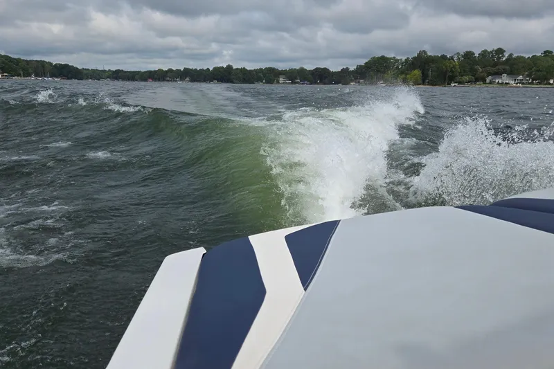 Slide: The Image of 2019 Axis T23 boat creating waves on a lake under cloudy skies. - 41