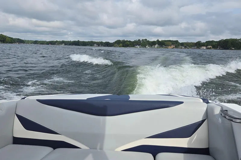 Slide: The Image of 2019 Axis T23 boat creating waves on a lake under cloudy skies. - 42
