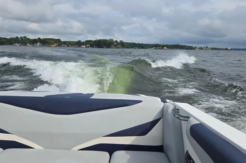 Slide: The Image of 2019 Axis T23 boat creating waves on a lake under cloudy skies. - 43