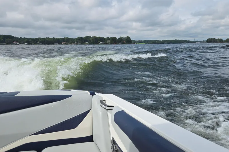 Slide: The Image of 2019 Axis T23 boat creating waves on a lake under cloudy skies. - 45