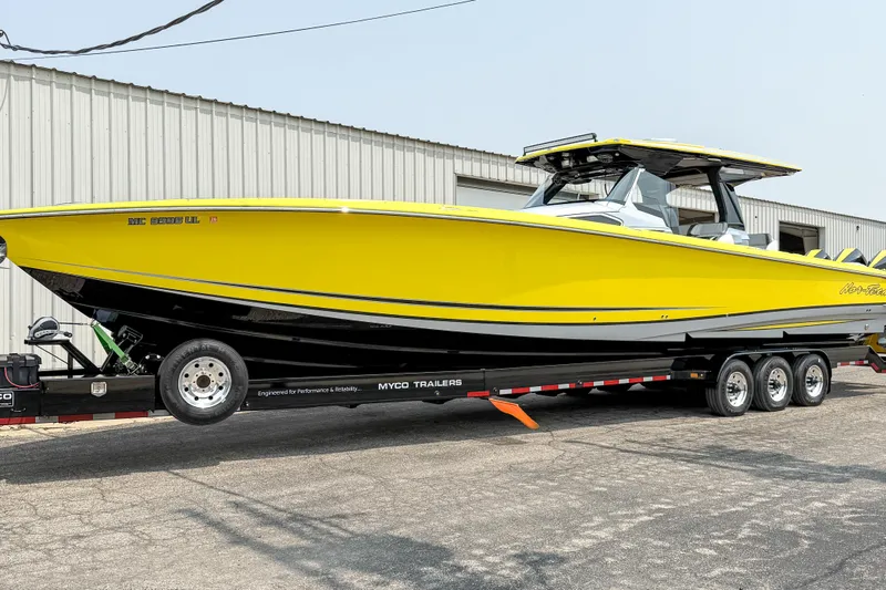 Slide: The Image of 2021 Nor-Tech 450 Sport boat in vibrant yellow on a trailer, parked outside a warehouse. - 10