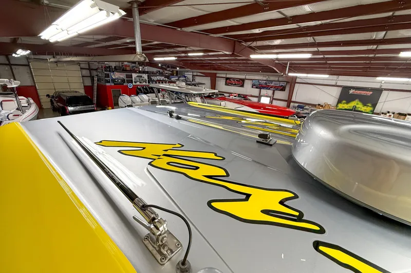 Slide: The Image of 2021 Nor-Tech 450 Sport boat in showroom, featuring vibrant yellow graphics. - 18