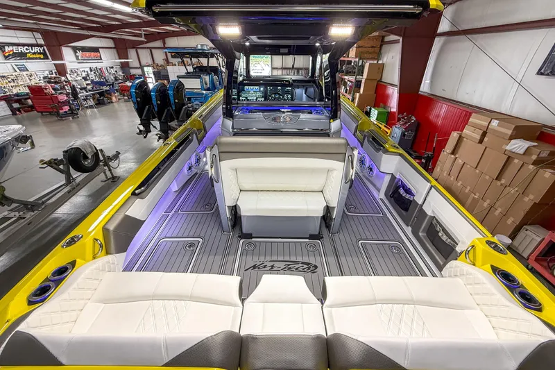 Slide: The Image of 2021 Nor-Tech 450 Sport boat interior with luxurious seating and modern design in a workshop setting. - 36