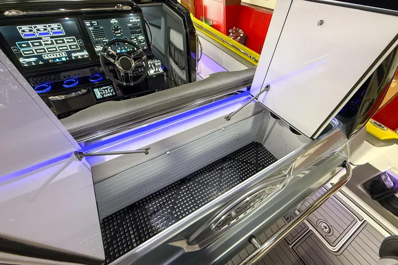 Slide: The Image of 2021 Nor-Tech 450 Sport boat interior with advanced control panel and storage compartment. - 38