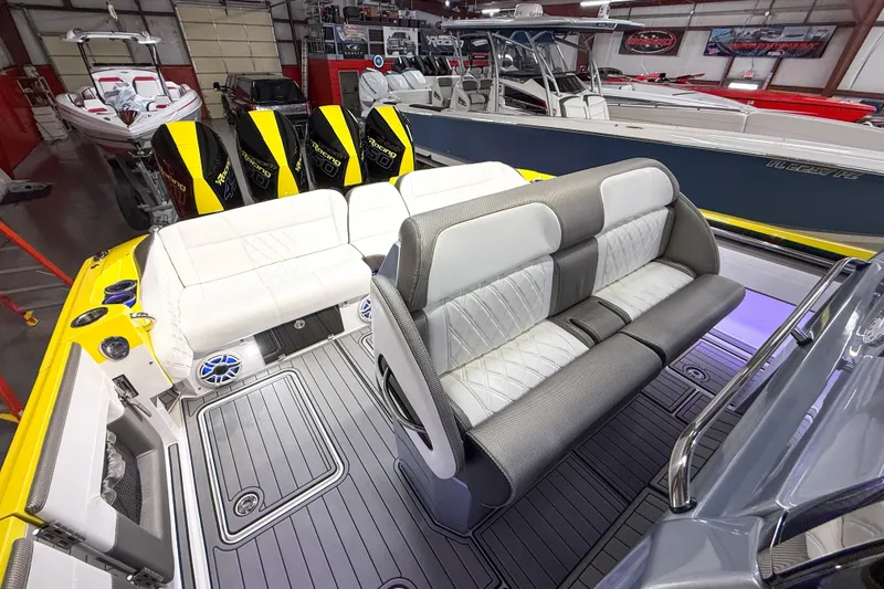 Slide: The Image of 2021 Nor-Tech 450 Sport boat interior with luxurious seating and powerful engines in a showroom. - 39