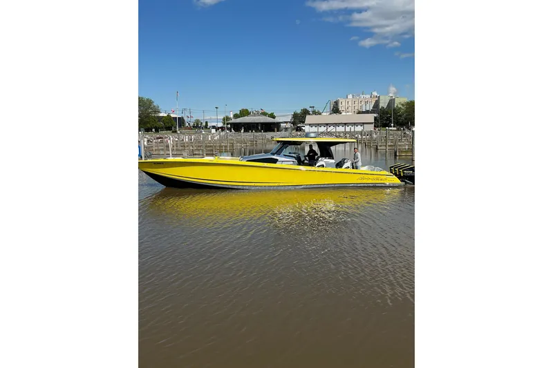 Slide: The Image of 2021 Nor-Tech 450 Sport boat in vibrant yellow, docked in a marina under a clear blue sky. - 4
