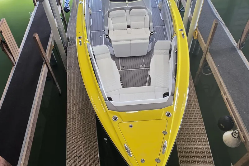 Slide: The Image of 2021 Nor-Tech 450 Sport boat with yellow exterior and white seating, docked in a marina. - 7