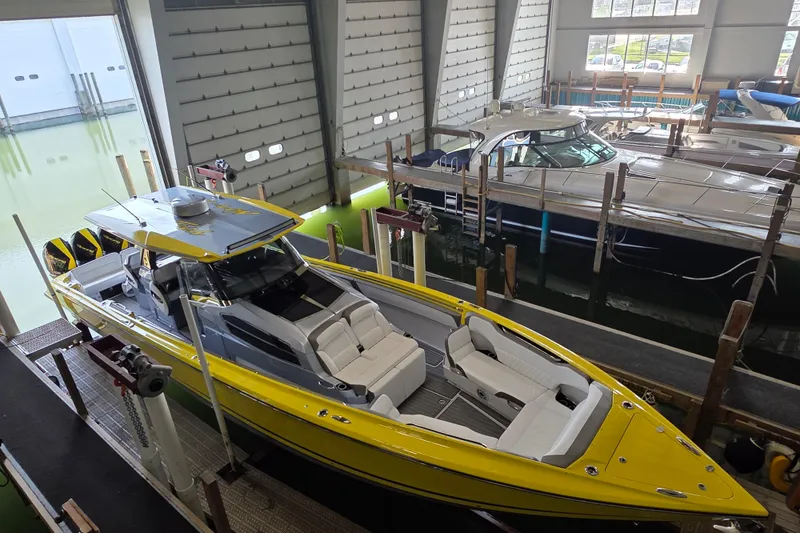 Slide: The Image of 2021 Nor-Tech 450 Sport boat in a marina, featuring a vibrant yellow exterior. - 8