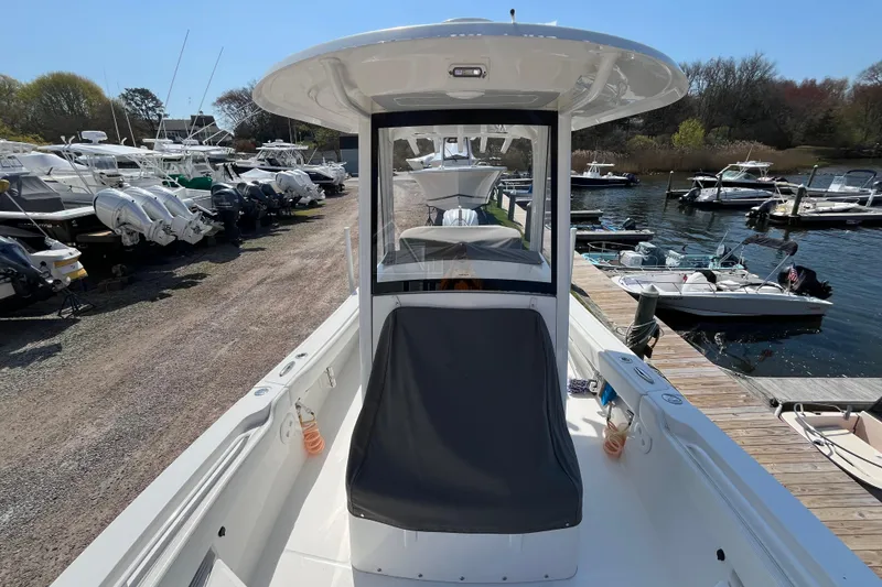 Slide: The Image of 2021 Regulator 24XO boat interior with seating and storage, docked among other boats. - 11