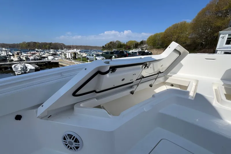 Slide: The Image of 2021 Regulator 24XO boat with open storage compartment, surrounded by other boats in a marina. - 13