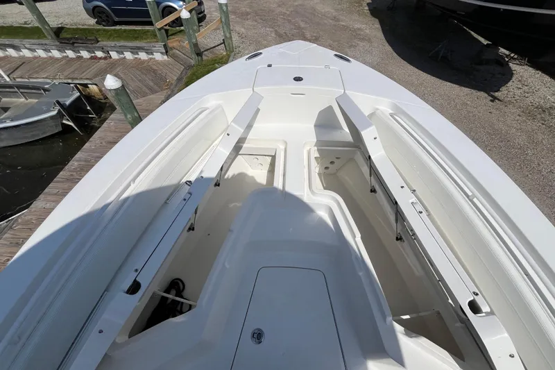 Slide: The Image of 2021 Regulator 24XO boat with covered seats, docked by a scenic waterfront. - 15