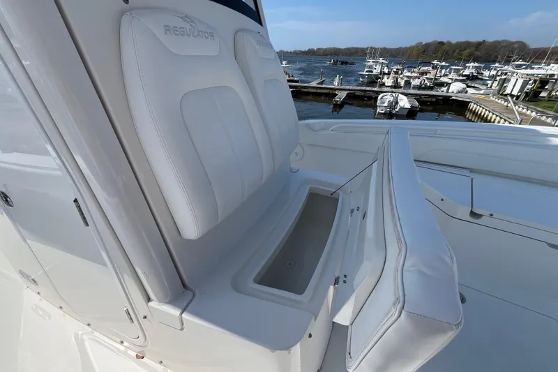 Slide: The Image of 2021 Regulator 24XO boat interior with open storage compartments at a marina. - 18