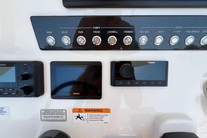 Slide: The Image of 2021 Regulator 24XO boat interior with white seating and storage, docked at marina. - 23