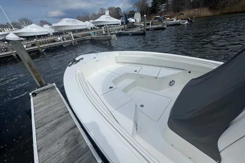 Slide: The Image of 2021 Regulator 24XO boat docked at marina, showcasing spacious deck and seating area. - 5