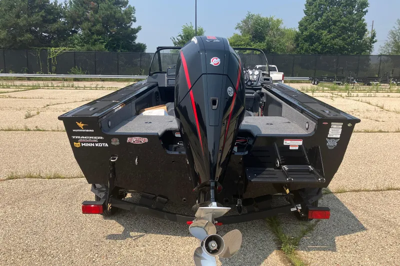 Slide: The Image of 2025 Tracker Targa V-19 Combo boat with powerful outboard motor, parked on pavement. - 2