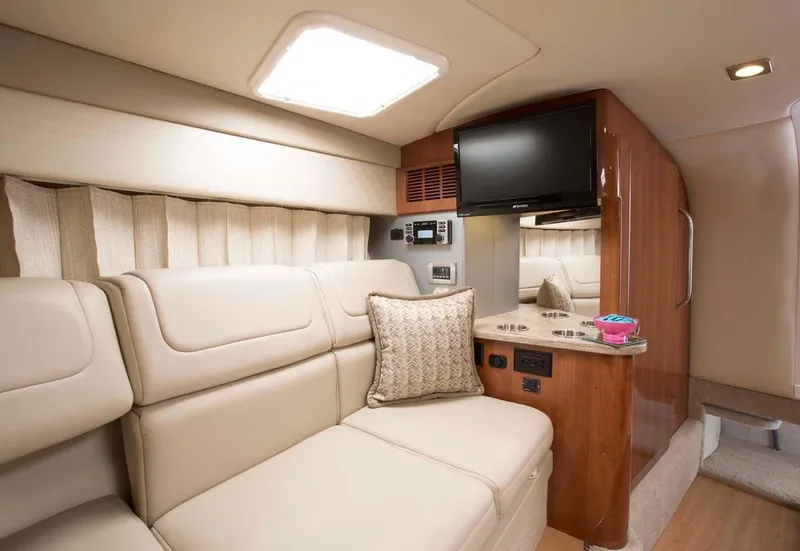 Slide: The Image of 2018 Formula 310 Sun Sport boat interior with seating and tables on turquoise water. - 22