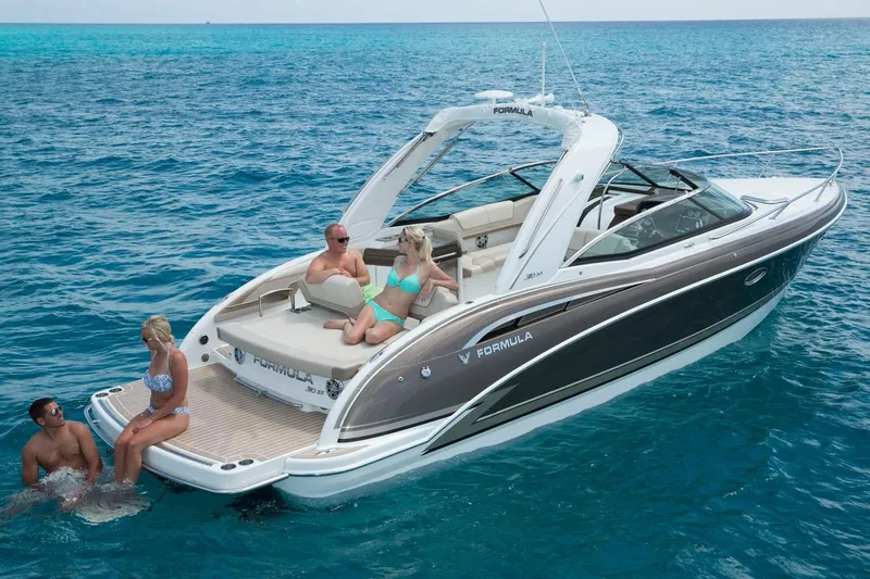 Slide: The Image of 2018 Formula 310 Sun Sport boat with people relaxing on deck in clear blue water. - 29