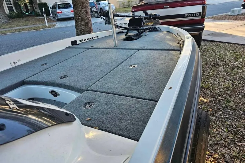 Slide: The Image of 2008 Ranger Z520 Comanche boat with carpeted deck, parked near a Ford truck. - 13