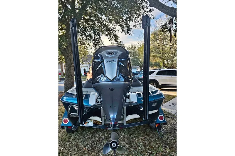 Slide: The Image of 2008 Ranger Z520 Comanche boat with motor, parked outdoors near trees. - 7