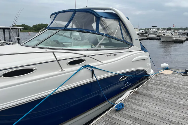 Slide: The Image of 2005 Chaparral 270 Signature boat docked at marina, featuring blue and white exterior. - 8