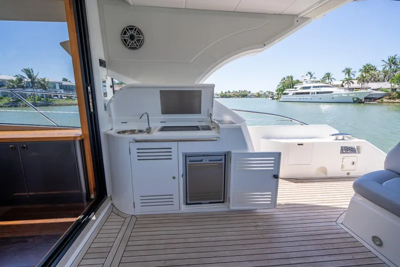 Slide: The Image of 2018 Sunseeker Predator 57 yacht deck with outdoor kitchen and scenic water view. - 34
