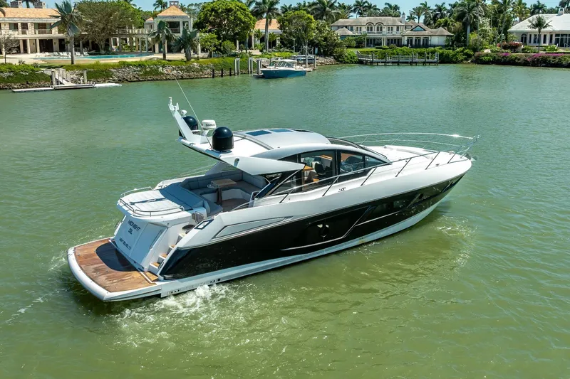 Slide: The Image of 2018 Sunseeker Predator 57 yacht cruising in a scenic waterfront setting. - 18