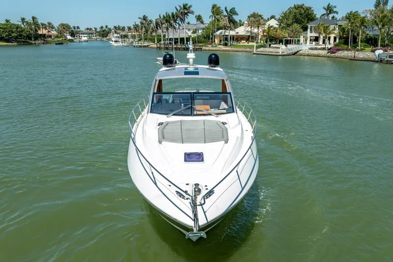 Slide: The Image of 2018 Sunseeker Predator 57 yacht cruising in a scenic waterfront area. - 22