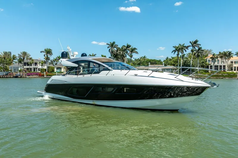 Slide: The Image of 2018 Sunseeker Predator 57 yacht cruising on a sunny day near luxury waterfront homes. - 95