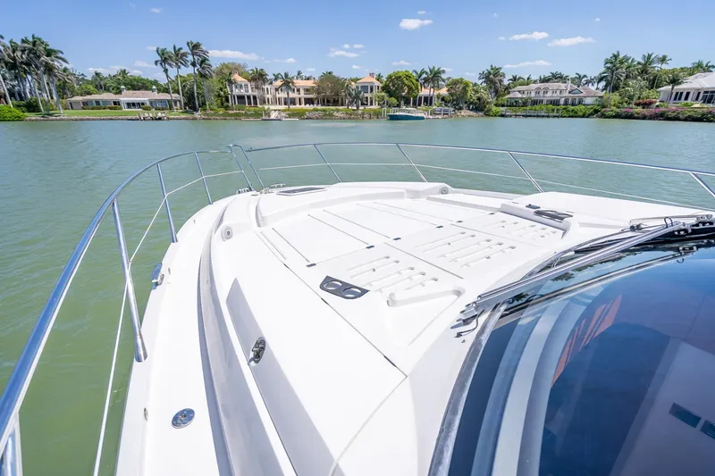 Slide: The Image of 2018 Sunseeker Predator 57 yacht cruising on a scenic waterway with luxury homes. - 29