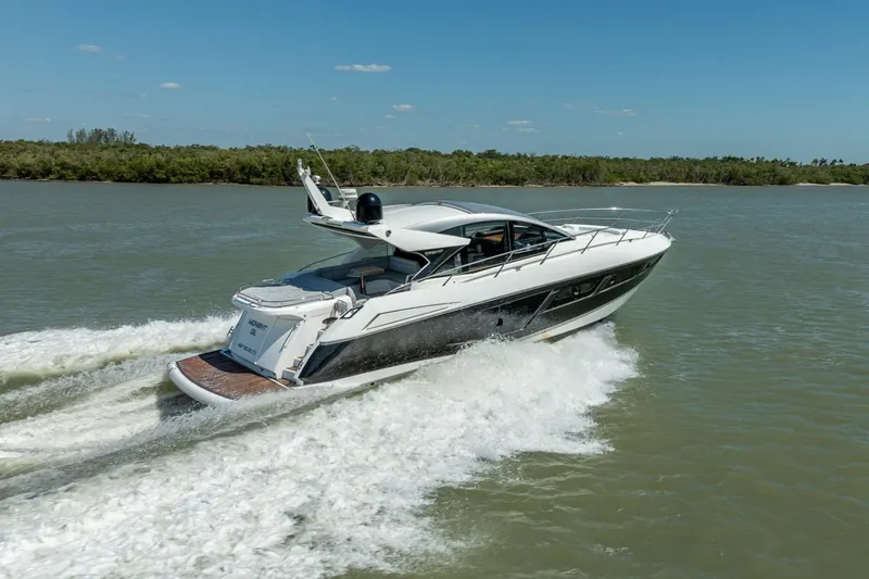 Slide: The Image of 2018 Sunseeker Predator 57 yacht cruising on a sunny day, surrounded by calm waters. - 97